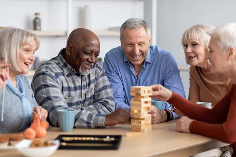 An elderly woman sits with a staff member reviewing a care plan together at a table.